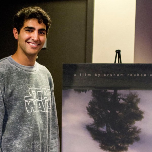 Arshum standing next to his A Day with God poster on the night of the film’s premiere.  